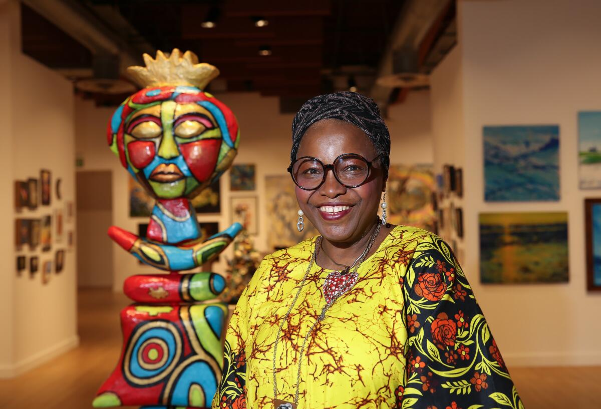 Adeola Davies-Aiyeloja is shown with her "Mother Earth, She Wears her Golden Crown" totem at Huntington Beach Art Center.