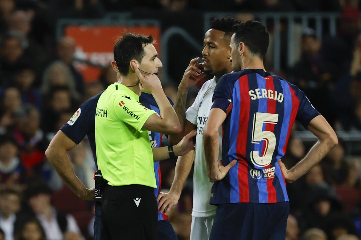 El árbitro Ricardo De Burgos Bengoetxea atiende al VAR durante el partido entre el Barcelona y el Real Madrid