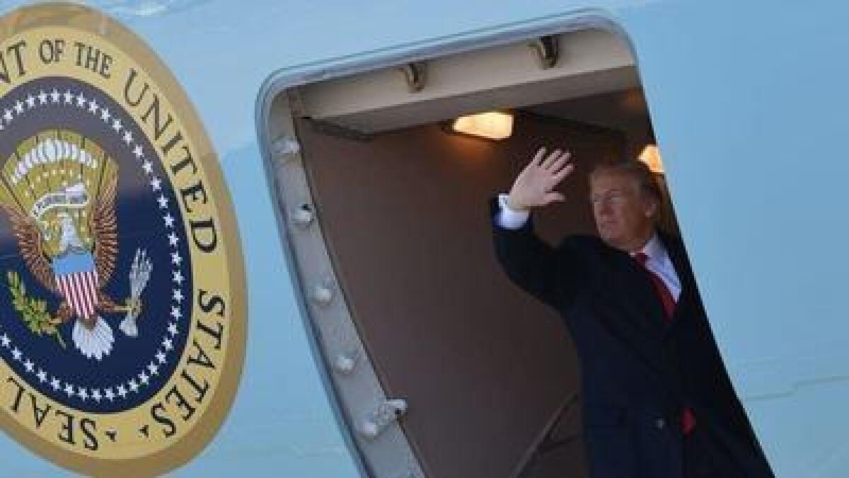 President Trump waves from the door of Air Force One