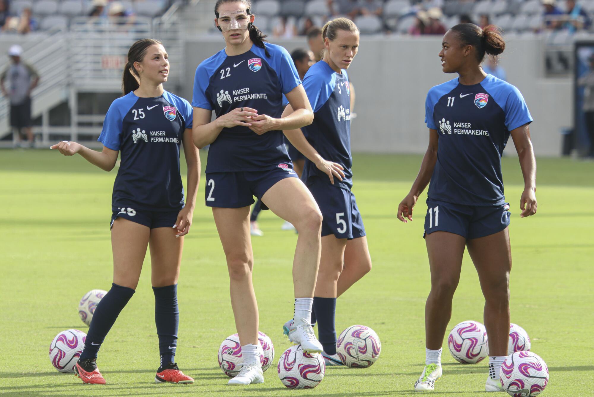 A woman talking to another woman on a soccer field