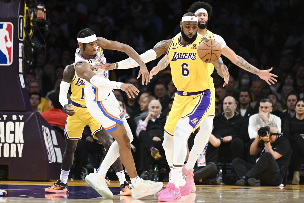 Lakers forward LeBron James and Thunder guard Shai Gilgeous-Alexander collide as they battle for a loose ball.