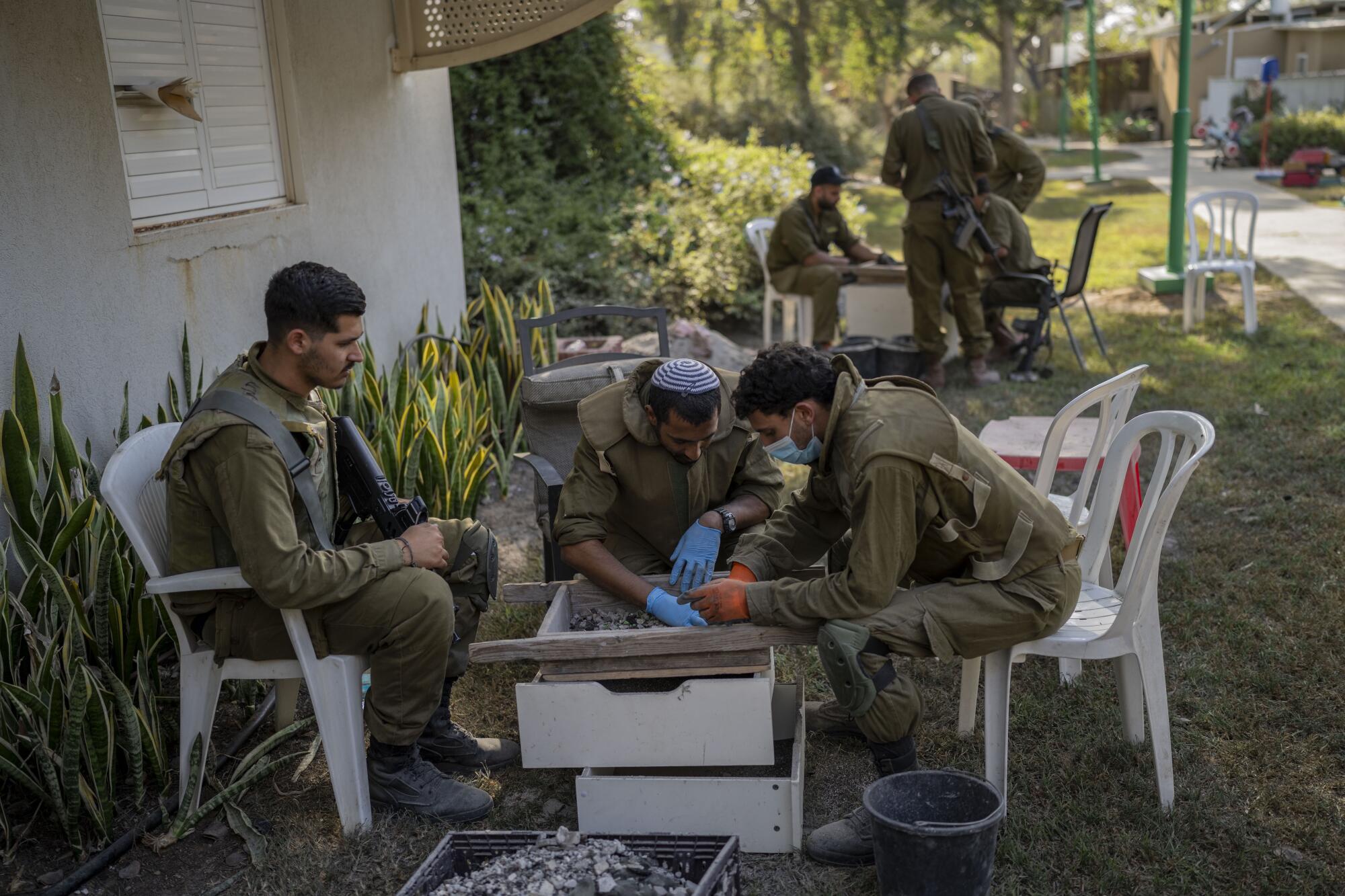Israeli soldiers examining items in a garden