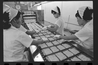 Women work on a ramen factory line.