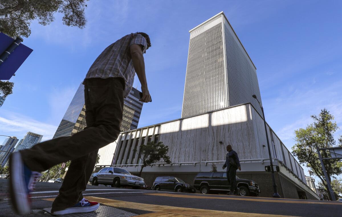 Pedestrians crossed A Street in front of the former Sempra building, located on Ash Street, in downtown San Diego.