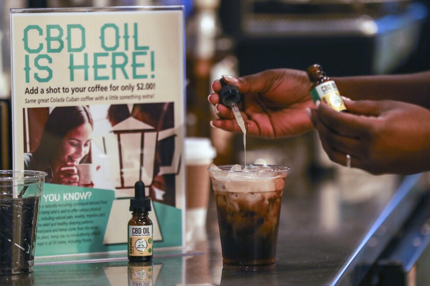 A worker adds cannabidiol, known as CBD, to a drink at a coffee shop in Fort Lauderdale, Fla.