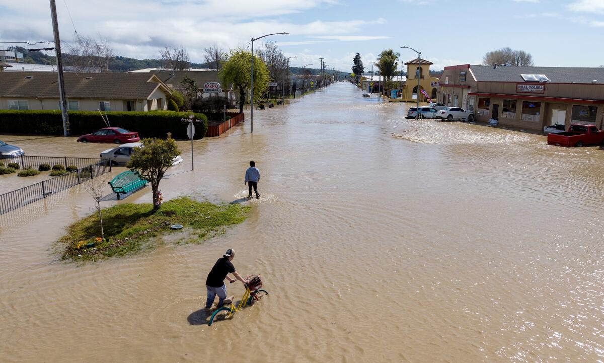 An aerial view shows people making their way around a flooded neighborhood in Pajaro.