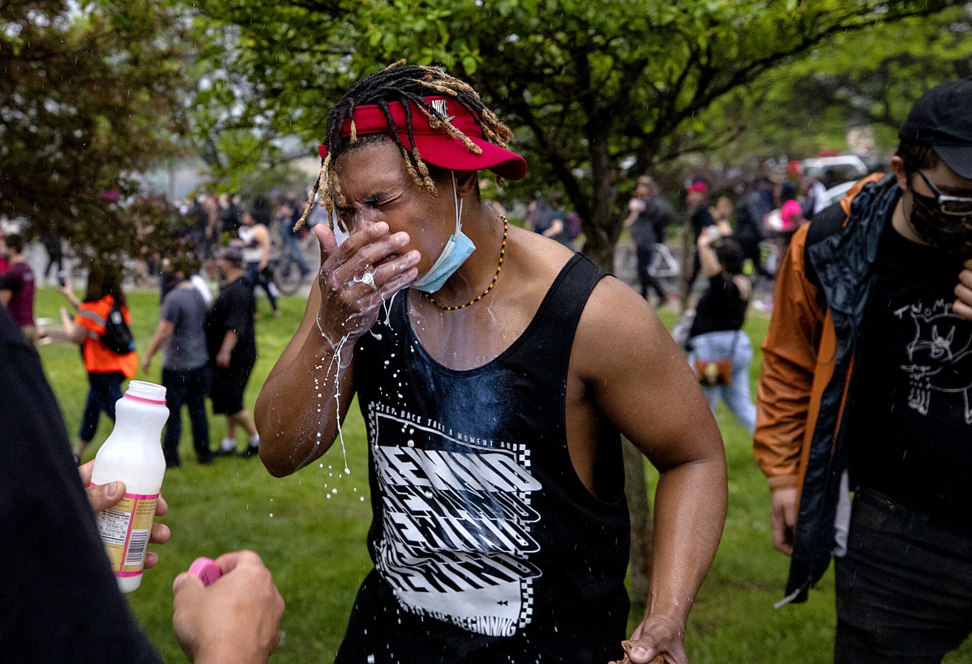 A protester wipes his face after being doused with milk after exposure to percussion grenades and tear gas.