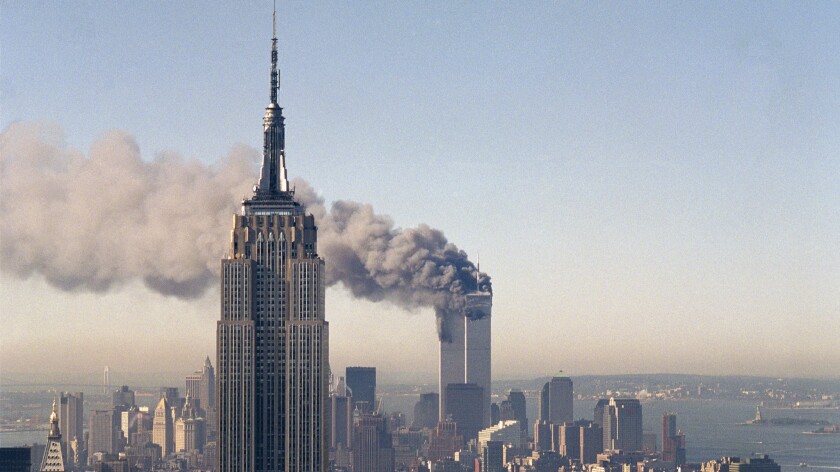 The twin towers of the World Trade Center burn behind the Empire State Building in New York on Sept. 11, 2001.