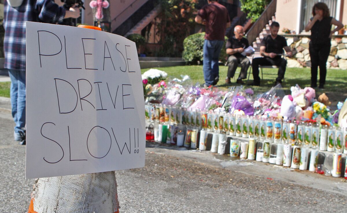 A sign warning drivers to slow down is placed next to the memorial site for 4-year-old Violeta Khachatoorians in Glendale on Monday, March 9, 2015. Three days prior, Violeta was killed by a hit-and-run driver, who eventually turned himself in.