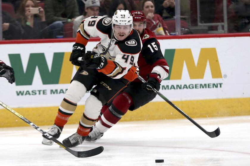 Anaheim Ducks' Max Jones (49) chases the puck against the Arizona Coyotes' Brad Richardson (15) during the first period of an NHL hockey game Wednesday, Nov. 27, 2019, in Glendale, Ariz. (AP Photo/Darryl Webb)