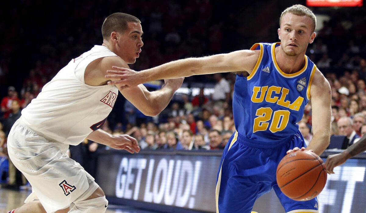 UCLA guard Bryce Alford drives past Arizona guard T.J. McConnell during the first half Saturday night in Tucson.