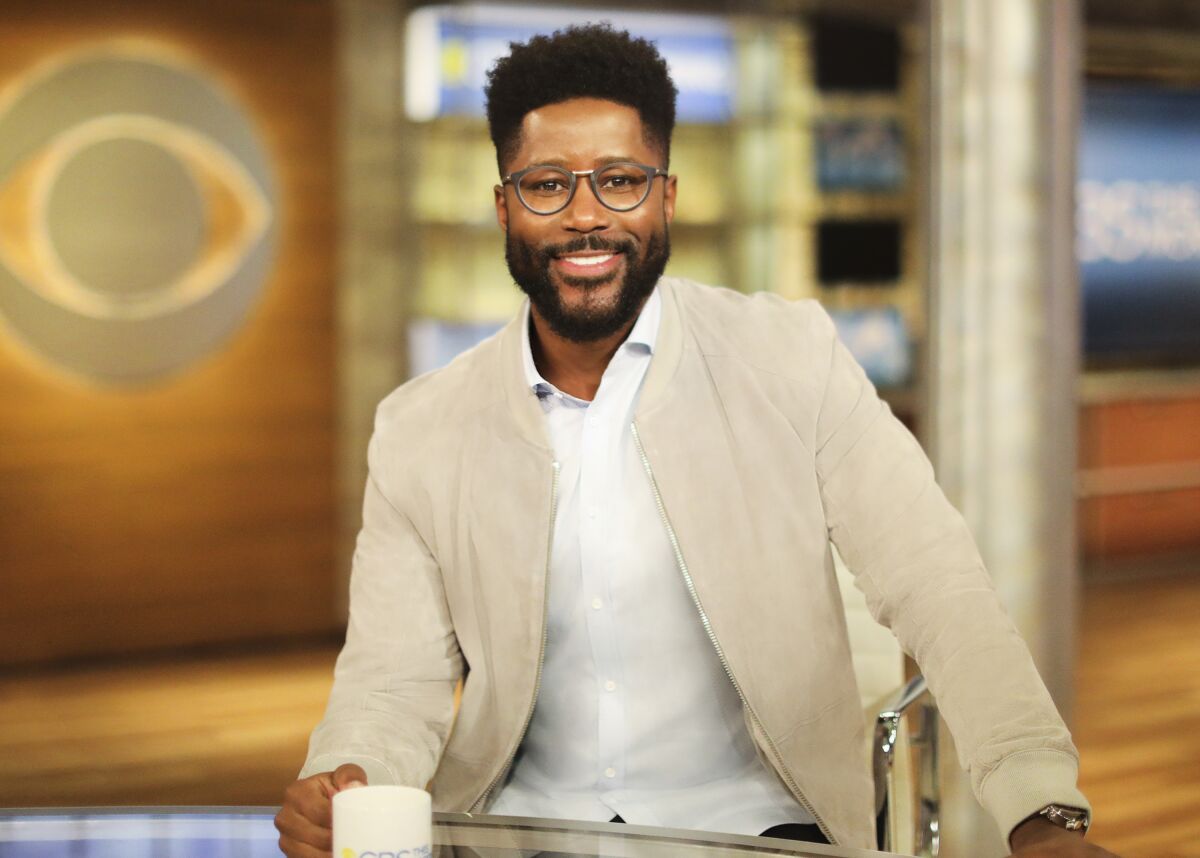 This image provided by CBS shows Nate Burleson on the set of "CBS This Morning." The former NFL player will join Gayle King and Tony Dokoupil on the show. (Michele Crowe/CBS via AP)