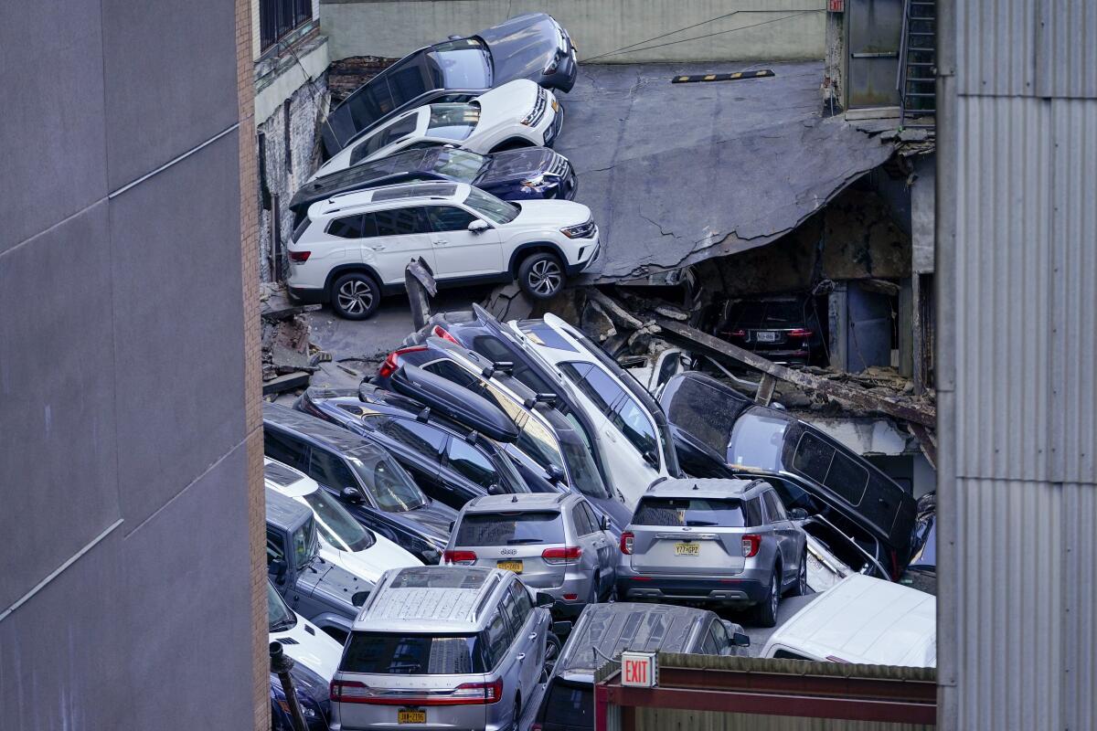 Vehículos apilados unos encima de otros en el lugar en el que un estacionamiento sufrió un derrumbe parcial