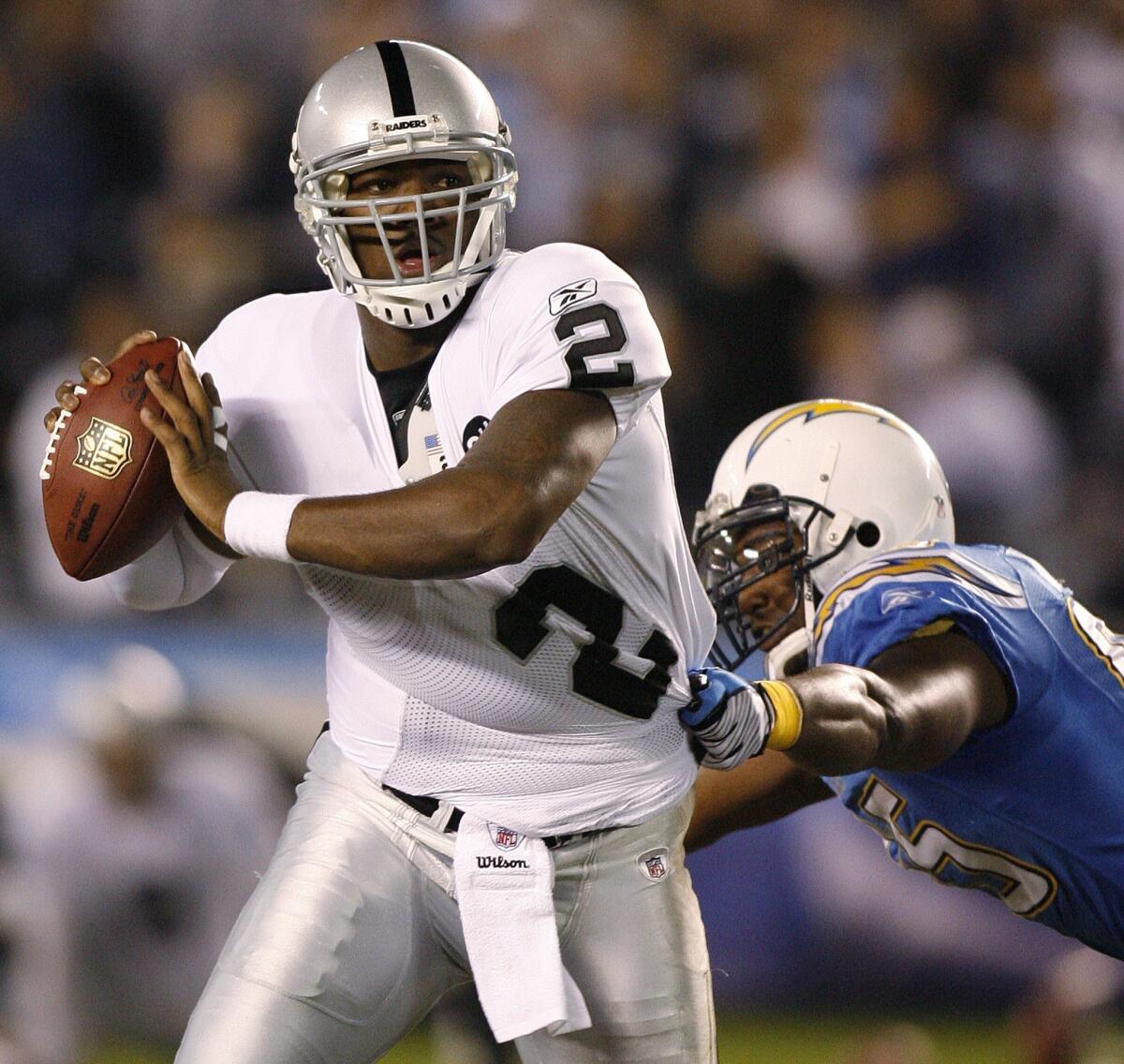 Oakland quarterback JaMarcus Russell tries to escape San Diego's Shaun Philips