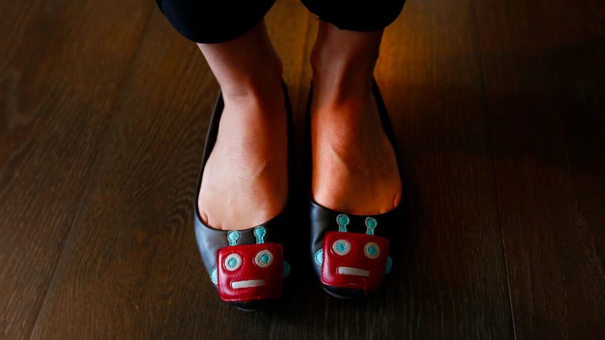 Alison Darcy, founder and chief executive of Woebot, shows off her robot-themed shoes. (Genaro Molina / Los Angeles Times)