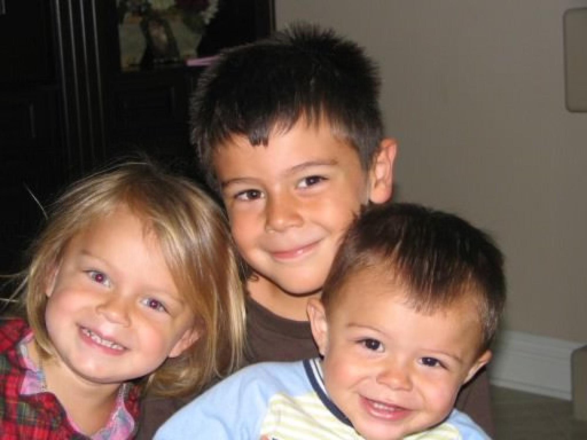 Gabriela, Jaime and Marcos Jaquez embrace during their childhood.