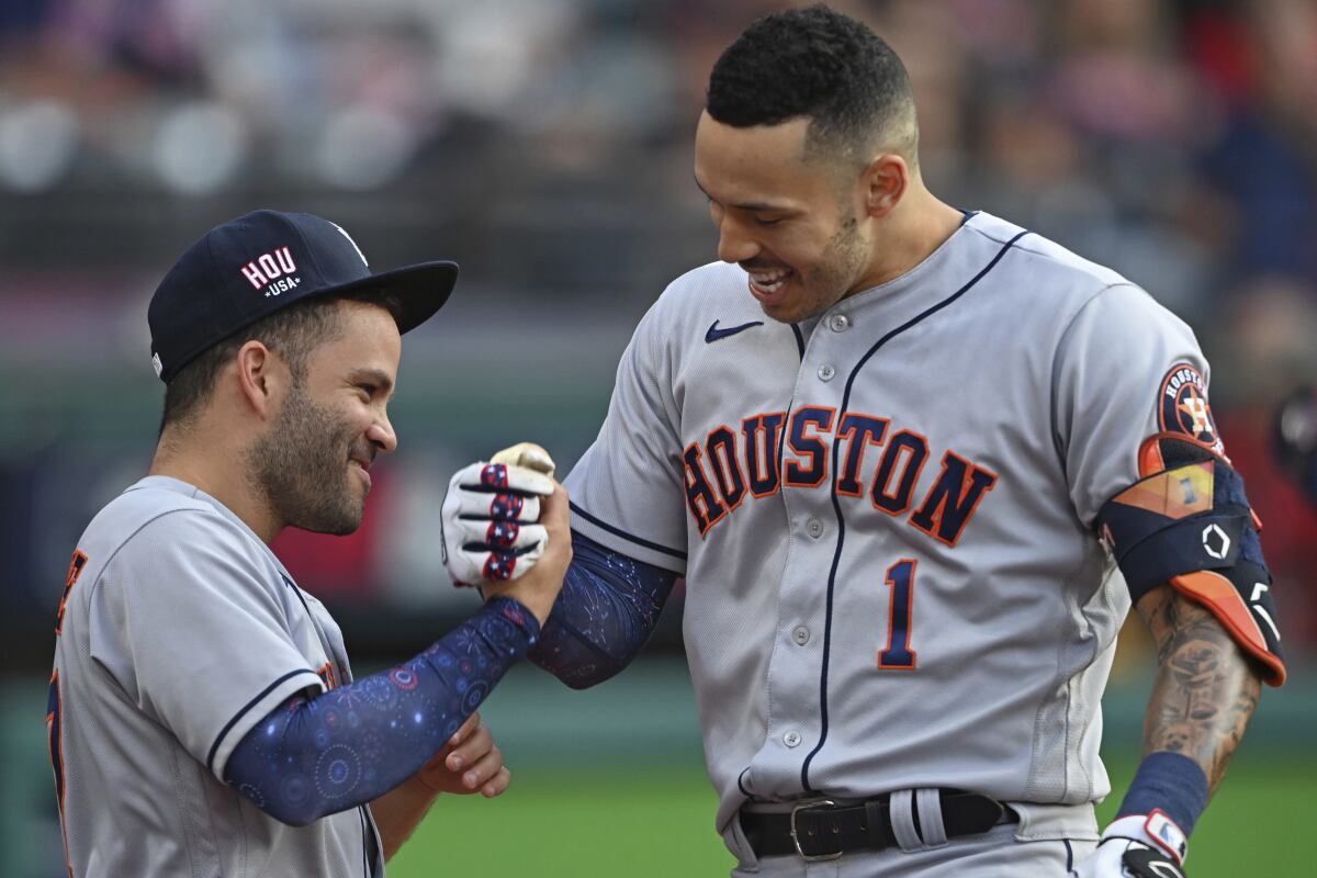 Houston Astros' Carlos Correa, right, is congratulated by Jose Altuve after hitting a solo home run off Cleveland Indians starting pitcher Eli Morgan during the fourth inning of a baseball game Saturday, July 3, 2021, in Cleveland. (AP Photo/David Dermer)