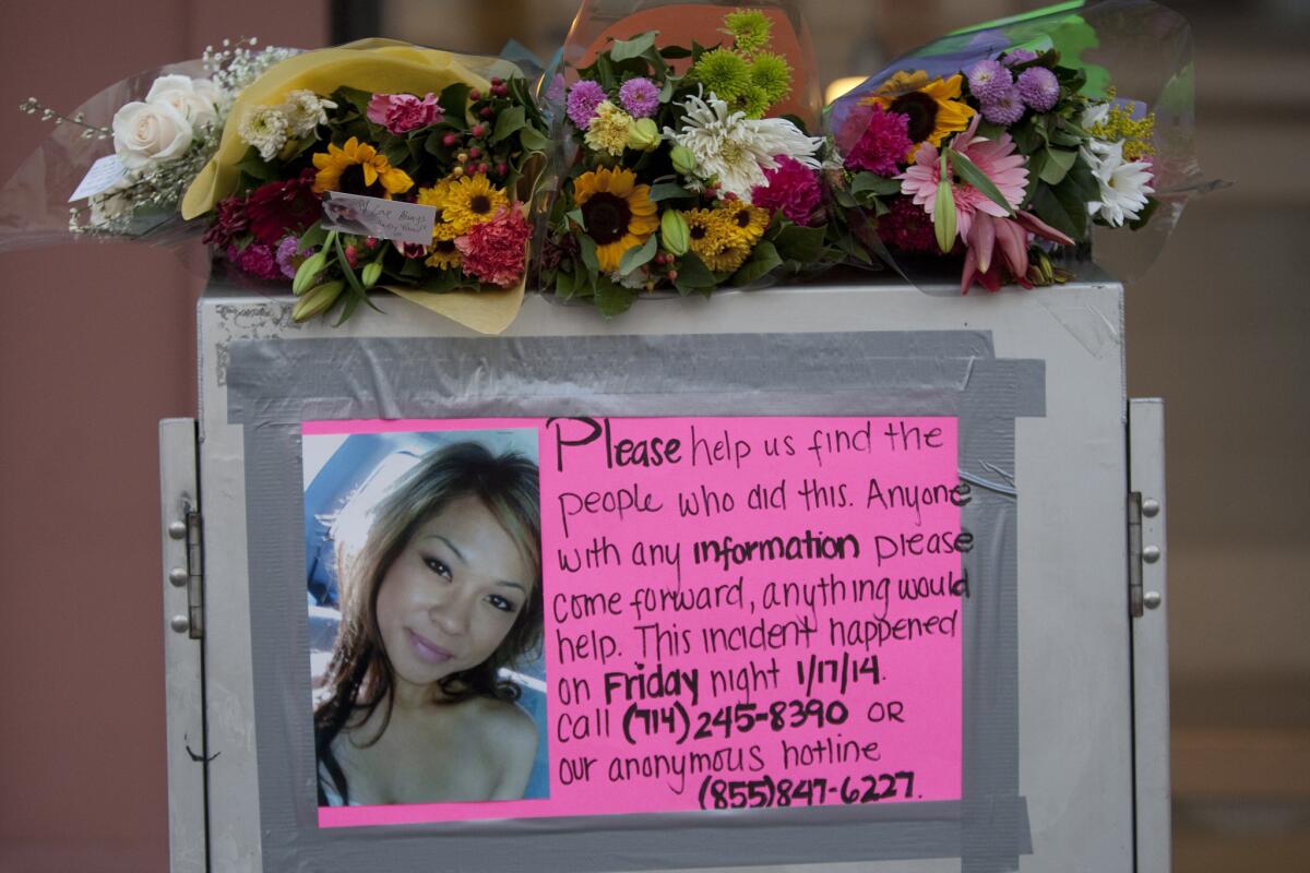 A poster seeking information is displayed at a memorial for Kim Pham, the 23-year-old woman who died after being attacked by a group of people outside a Santa Ana nightclub.