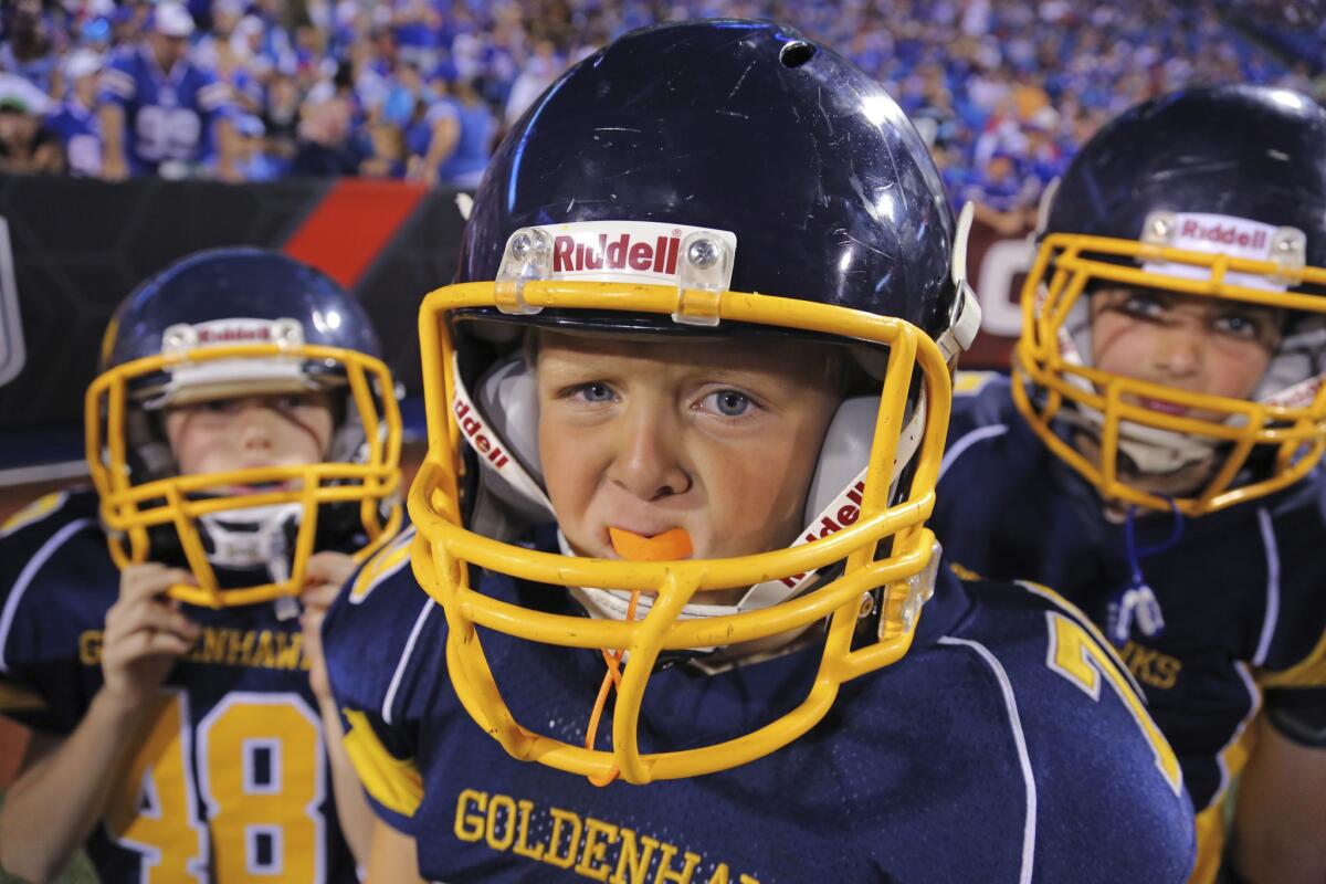 Youth football players leave the field during halftime of an NFL preseason football game in Orchard Park, N.Y.
