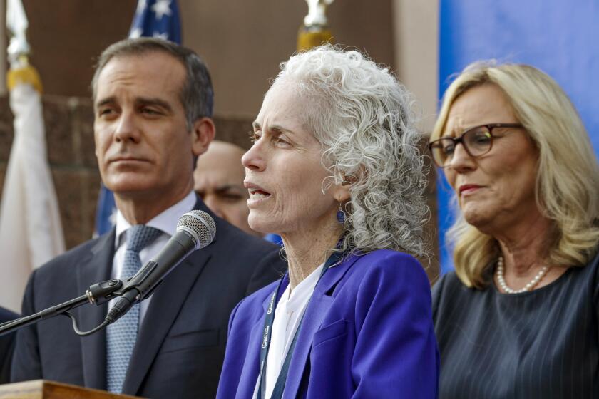 LOS ANGELES, CA - MARCH 04 , 2020 - L.A. County Department of Public Health Director Barbara Ferrer, center, flanked by Los Angeles Mayor Eric Garcetti, left, and L.A. County Supervisor Kathryn Barger address a press conference held at the steps at Kenneth Hahn Hall of Administration to declare a health emergency as the number of coronavirus cases increased to seven, with six new cases in Los Angeles County. None of the new cases are connected to "community spread," officials said. All individuals were exposed to COVID-19 through close contacts. The additional cases were confirmed Tuesday night. Officials said three of the new cases were travelers who had visited northern Italy, two were family members who had close contact with someone outside of the county who was infected, and one had a job that put them in contact with travelers. One person has been hospitalized, and the others are isolated at home. (Irfan Khan / Los Angeles Times)