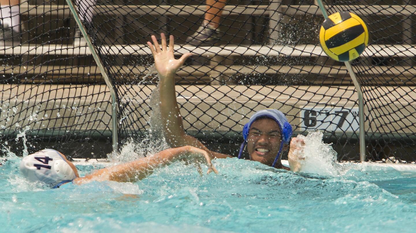 Corona del Mar High senior Tae Le is unable to stop freshmen Kat Snyder (14) from scoring a goal during a water polo game between senior football players and the girls' water polo team on Wednesday in Newport Beach. (Kevin Chang/ Daily Pilot)