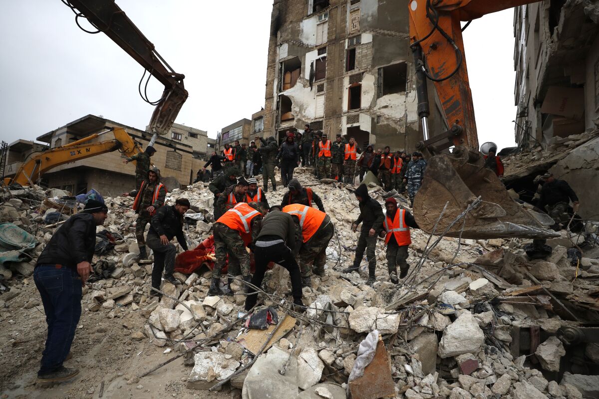 Civil defense workers and security forces searching through wreckage of collapsed buildings