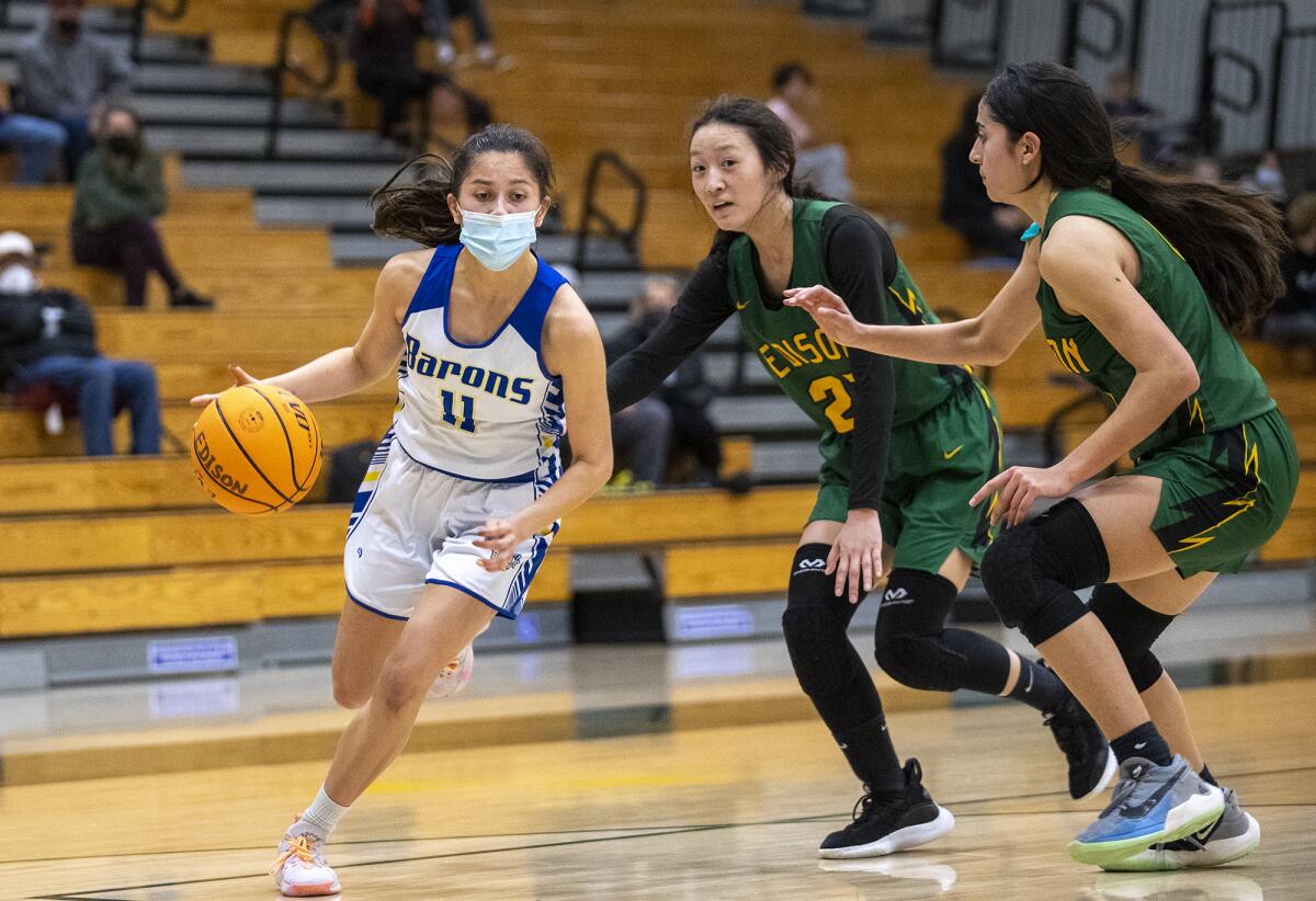 Fountain Valley's Audrey Tengan dribbles past Edison's Bailey Chang, center, and Sofia Aviles.