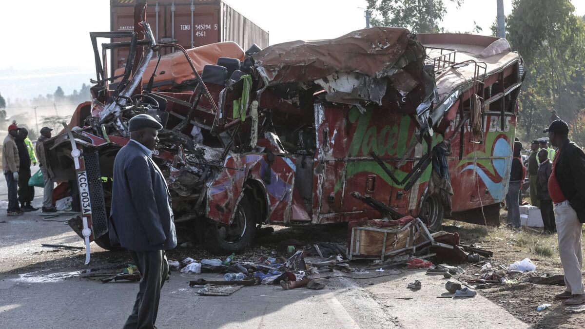 People view the wreckage of a bus and truck that collided near Nakuru, Kenya, on Sunday.