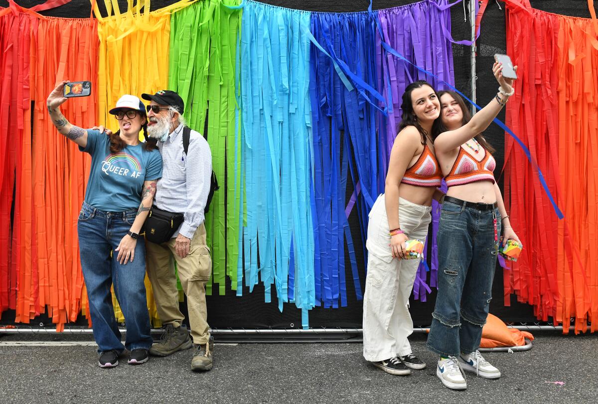 People take selfies along Hollywood Boulevard during the Gay Pride Parade.
