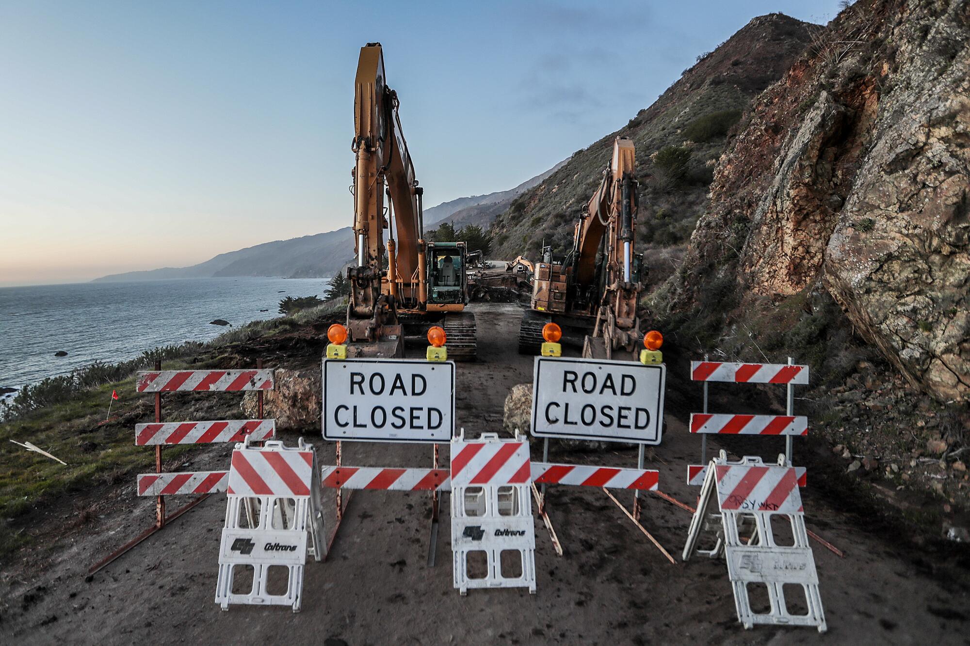 Two "Road Closed" signs in front on heavy road equipment.