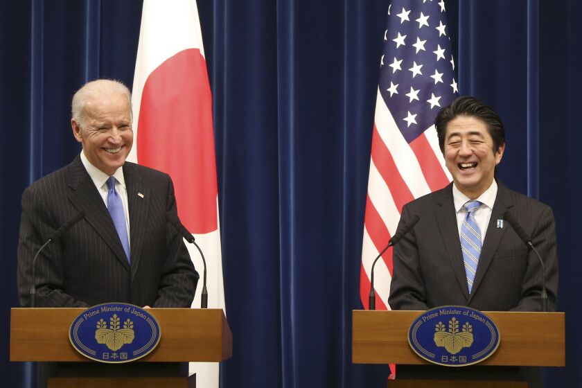 U.S. Vice President Joe Biden and Japanese Prime Minister Shinzo Abe smile together during a joint press conference following their meeting at Abe's official residence in Tokyo Tuesday, Dec. 3, 2013. Biden voiced strong opposition Tuesday to China's new air defense zone above a set of disputed islands, showing a united front with an anxious Japan as tension in the region simmered. Standing side by side in Tokyo with Abe, Biden said the U.S. is "deeply concerned" about China's attempt to unilaterally change the status quo in the East China Sea. (AP Photo/Koji Sasahara)