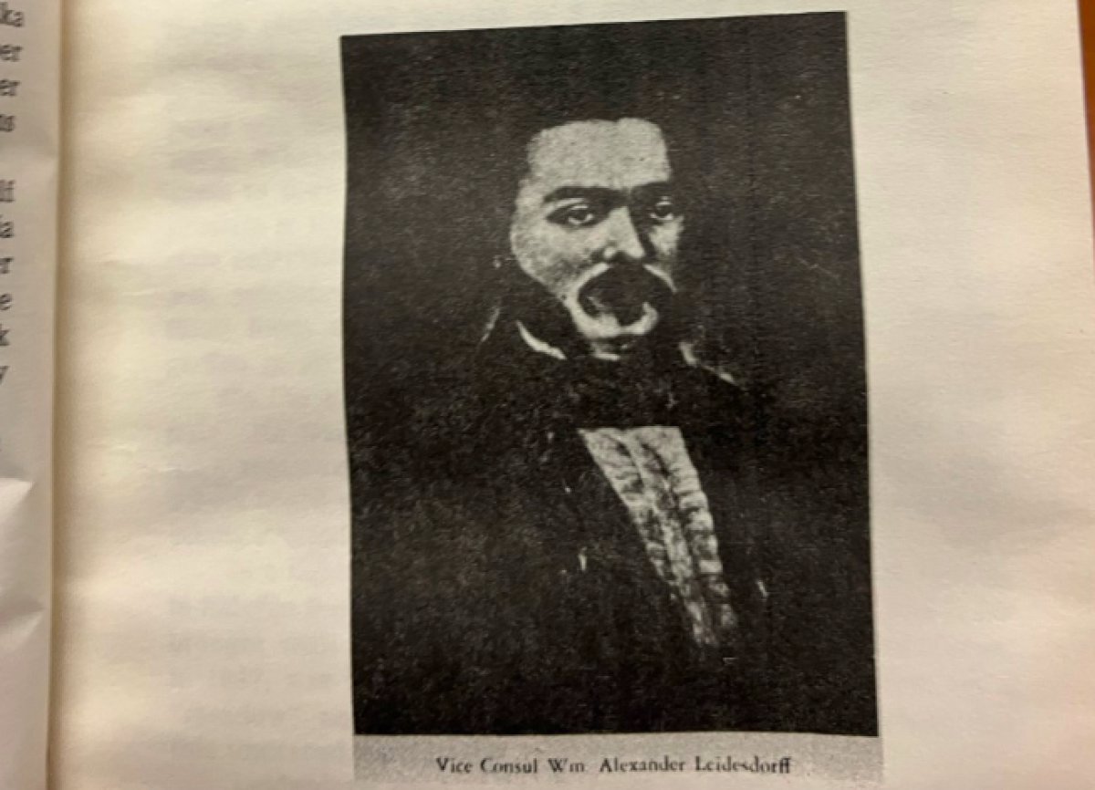 A photo of a man with large sideburns and in formalwear.