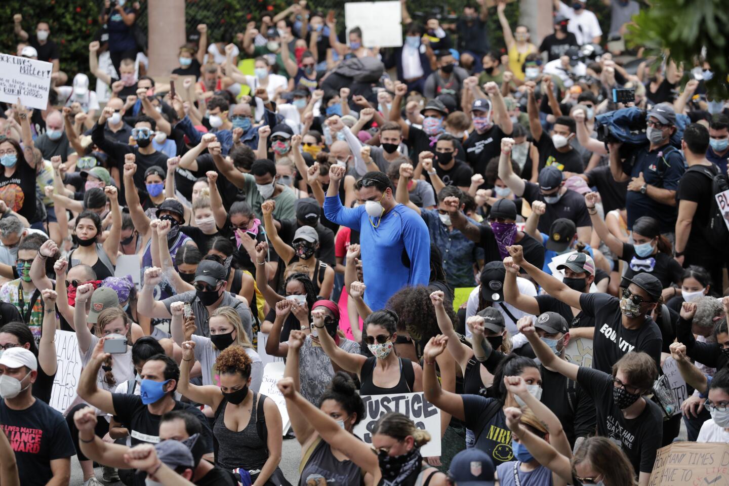 People raise their fists during a protest over the death of George Floyd, Saturday in Miami.