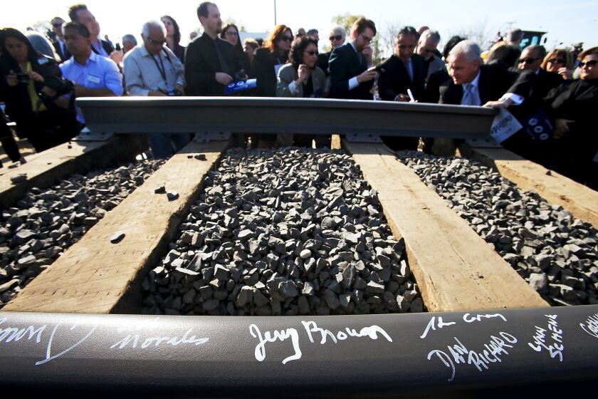 Guests sign a rail segment during a groundbreaking ceremony for a bullet train station in Fresno on Jan. 6.