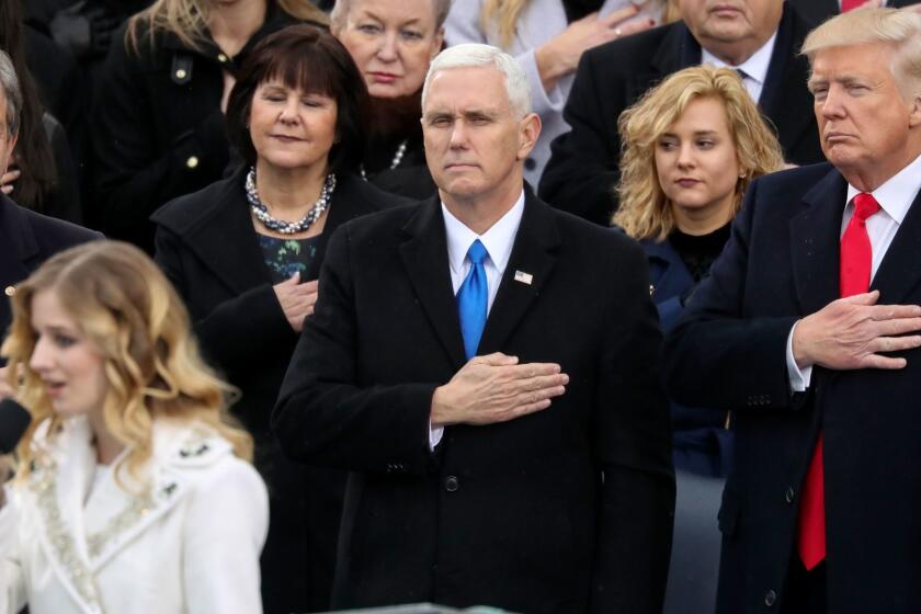 Vice President Mike Pence and President Trump listen to Jackie Evancho sing the national anthem during Trump's inauguration.