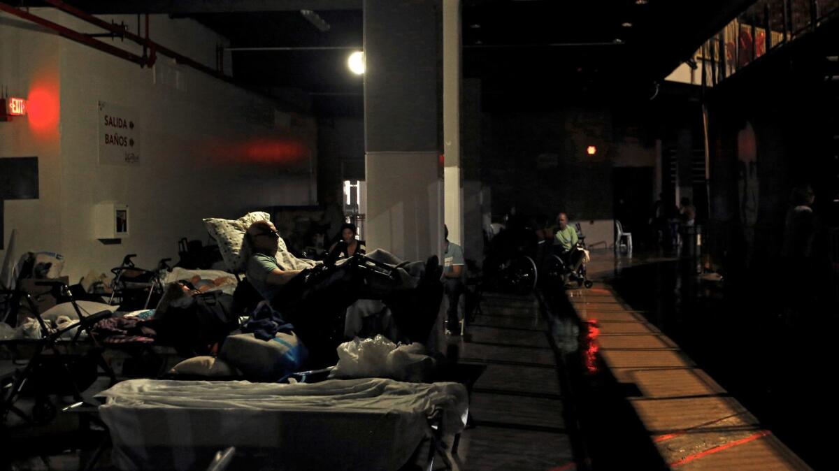 Evacuees rest in almost complete darkness in Roberto Clemente Coliseum, a major shelter in San Juan. (Carolyn Cole / Los Angeles Times)