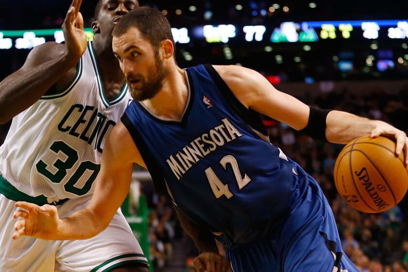 Minnesota's Kevin Love, right, drives past Boston's Brandon Bass during a game in December. Love was traded to the Cleveland Cavaliers on Saturday.