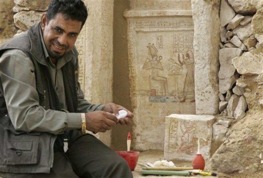 An archaeology worker cleans hieroglyphic details on a white limestone casing at the site of a newly-discovered pyramid at Saqqara near Cairo, Egypt, Tuesday, Nov. 11, 2008. Egypt's antiquities chief Zahi Hawass, not seen, announced the discovery of the new pyramid, dated about 4,300 years old and said to belong to Queen Sesheshet, the mother of King Teti, founder of the 6th Dynasty of Egypt's Old Kingdom. (AP Photo/Ben Curtis)