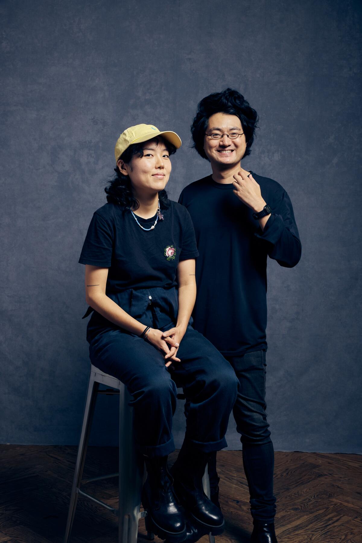 Park Ji-Min sits on a stool with director Davy Chou standing next to her for a portrait.
