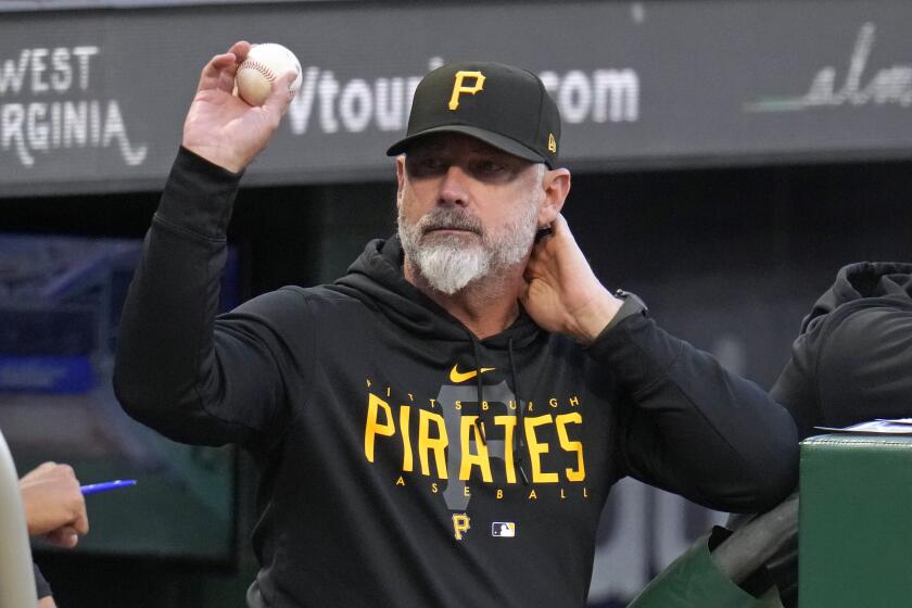 Derek Shelton, manager de los Piratas de Pittsburgh, lanza una pelota de foul a un fanático durante la primera entrada del juego de béisbol en contra de los Nacionales de Washington, en Pittsburgh, el miércoles 13 de septiembre de 2023. (AP Foto/Gene J. Puskar)