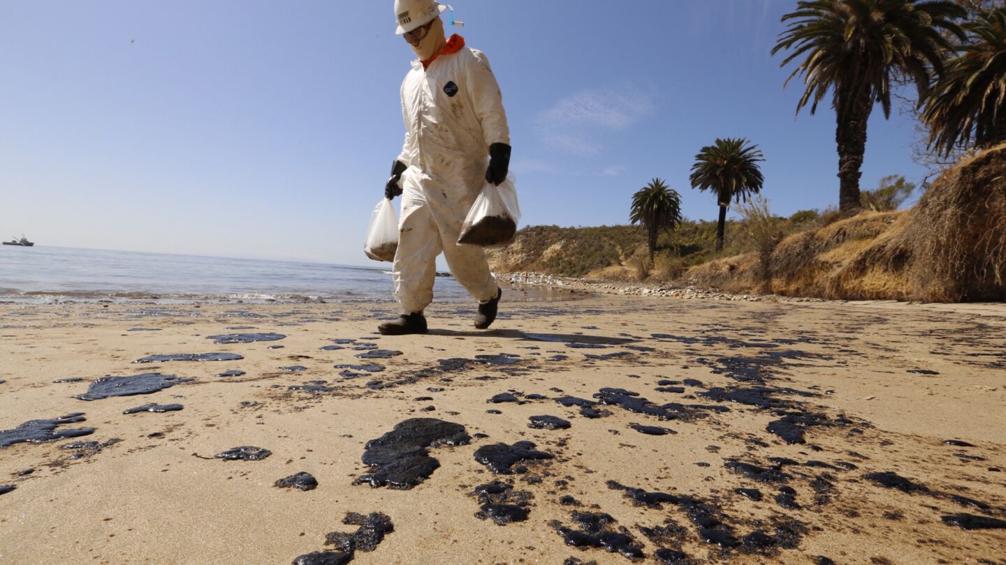 Crews from West Coast Environmental bag oiled sand on the beach as a cleanup operation began at Refugio State Beach on Wednesday morning.