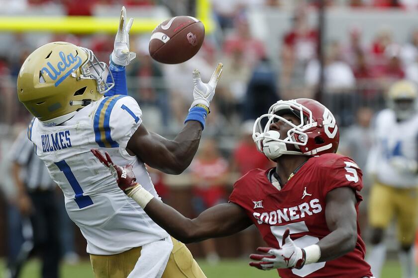 UCLA cornerback Darnay Holmes intercepts a pass intended for Sooners receiver Marquise Brown in the third quarter.