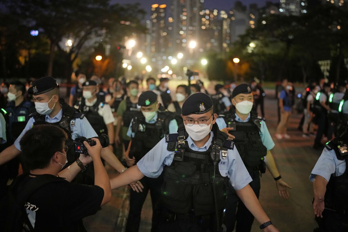 Police officers stop people entering the Hong Kong's Victoria Park, Saturday, June 4, 2022. Heavy police force patrolled Hong Kong's Victoria Park on Saturday after authorities for a third consecutive year banned public commemoration of the anniversary of the deadly Tiananmen Square crackdown in 1989, with vigils overseas the only place marking the event. (AP Photo/Kin Cheung)