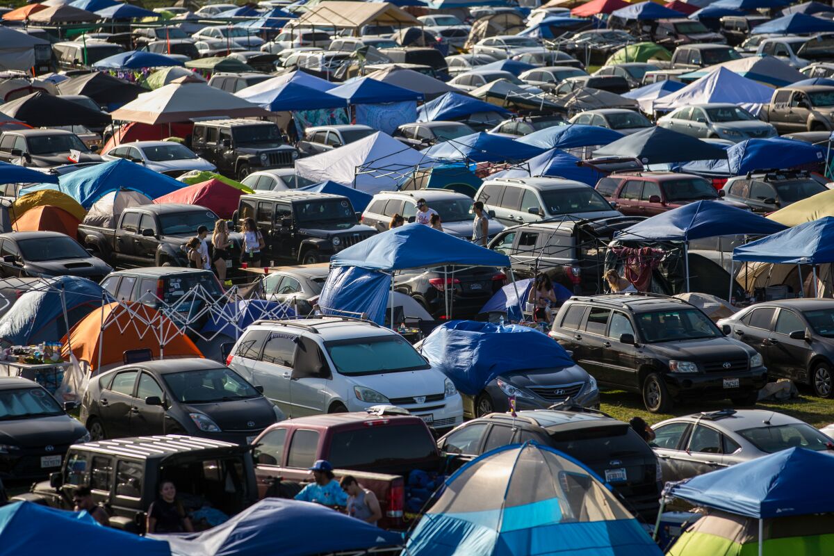 İnsanlar kamp kurarken çadırlar toplanır.
