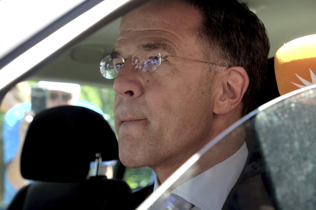 Dutch Prime Minister Mark Rutte sits in a car as he leaves Palace Huis ten Bosch in The Hague, Netherlands