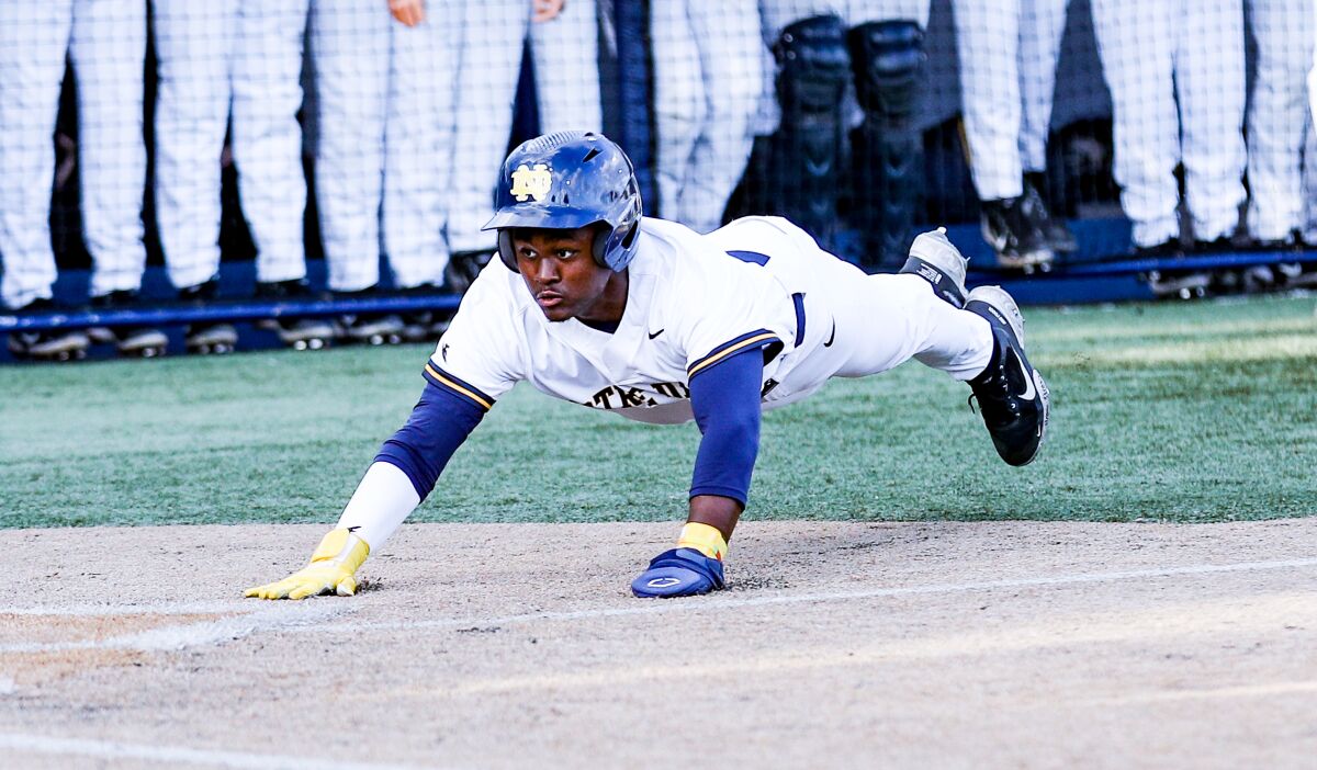 Dean West of Sherman Oaks Notre Dame slides into home plate to score in the first inning on Tuesday