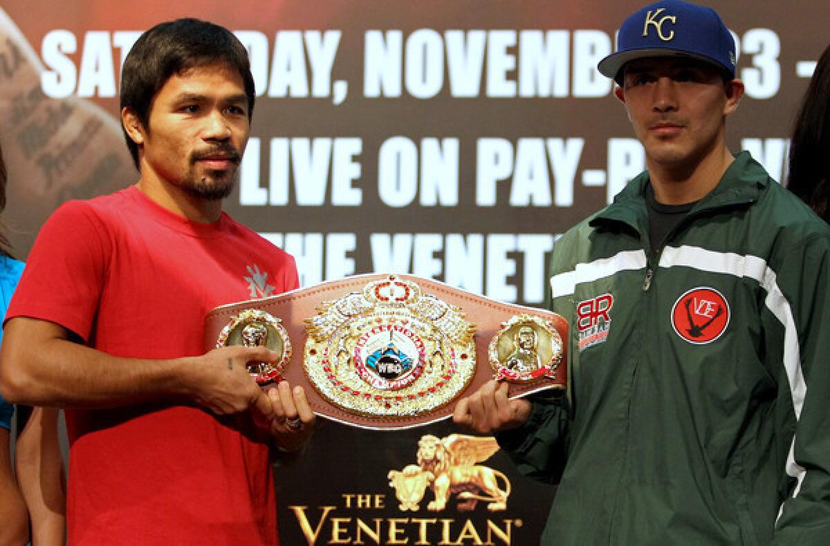 Boxer Manny Pacquiao, left, and Brandon Rios pose with the belt during a news conference in Macau on Wednesday.