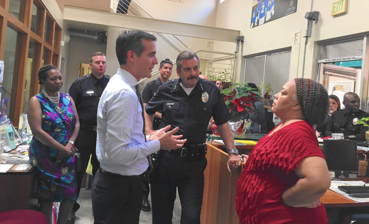 Mayor Eric Garcetti, left, and Police Chief Charlie Beck speak with Felica Jones, director of programs for Healthy African American Families II, during their visit to Leimert Park.