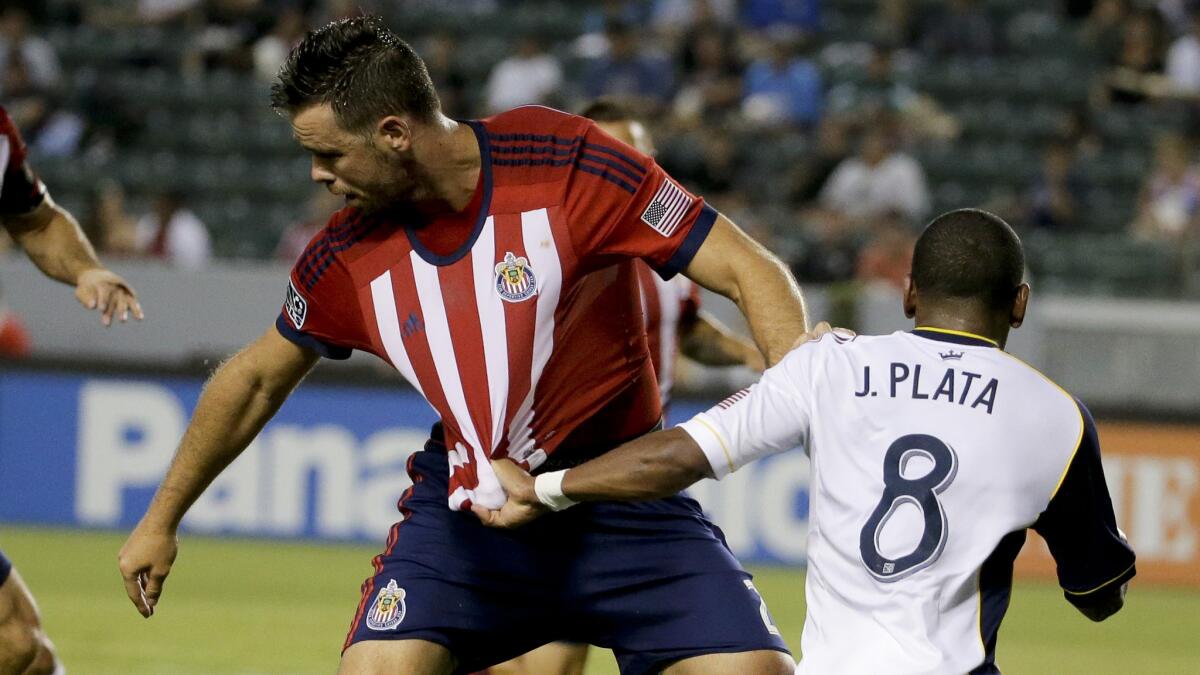 Real Salt Lake forward Jou Plata, right, pulls the jersey of Chivas USA defender Bobby Burling during a match on June 28.
