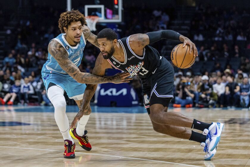Charlotte Hornets guard Kelly Oubre Jr. guards LA Clippers guard Paul George (13) as he drives with the ball during the first half of an NBA basketball game on Monday, Dec. 5, 2022, in Charlotte, N.C. (AP Photo/Scott Kinser)